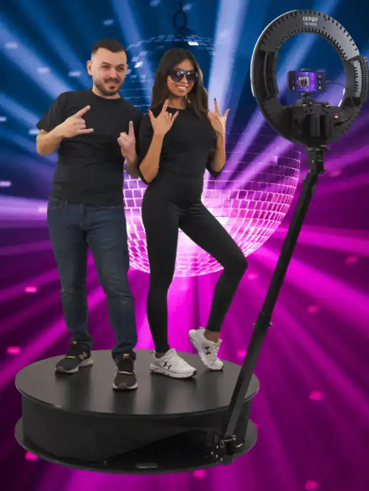 Två personer i fotobås med discokulor och ljusshow.